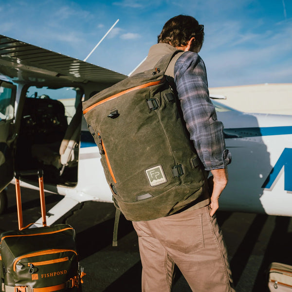 Person with a backpack boarding a small airplane