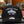 Black cap with branding on a glass table in a store setting