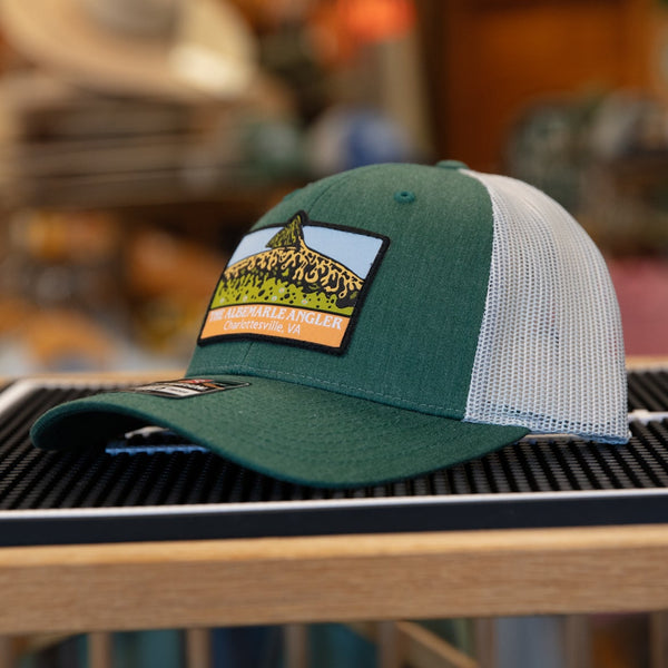 Green and white cap with a patch on a grill