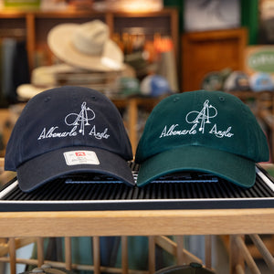 Two baseball caps with logos on a display rack in a store setting.