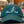 Green cap with branding on a black mat in a store setting
