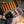 Open fly fishing lure case with various lures held by a person against a blurred natural background.
