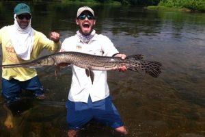A very happy angler and fishing guide holding a gar. Caught in the James River Virginia.
