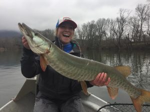 Angler with her first musky, caught on a fly.