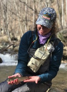 Female angler with a brook trout caught on a fly fishing guide trip.