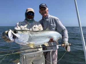 Fly fishing guide and angler with a tarpon caught in Isla de la Juventud, Cuba. Fly fishing from Avalon 1 fleet mother ship.