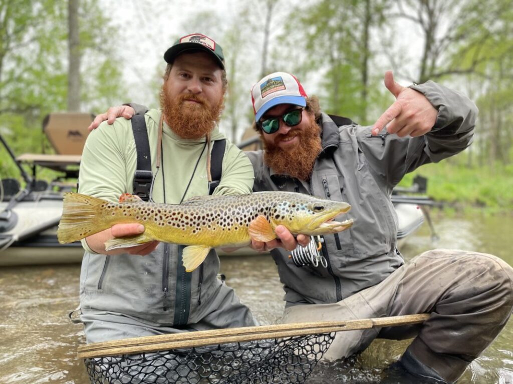 Two fly fisherman with a brown trout caught on the Jackson River in Bath County in Virginia, while fishing from the SmithFly Big Shoals boat.